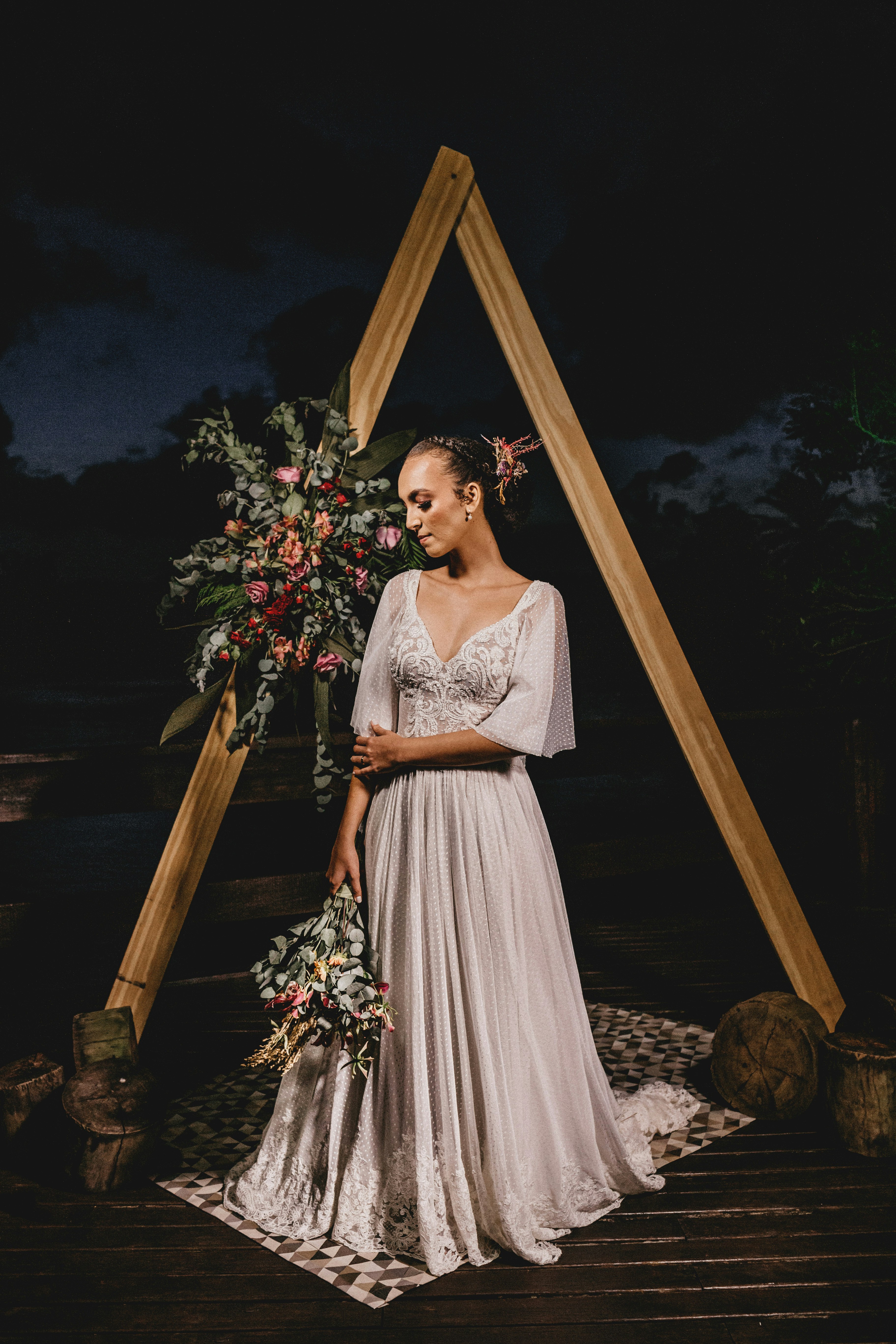 woman in white floral dress standing on brown wooden ladder